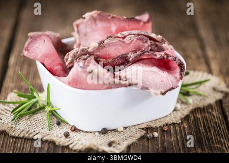 Partie de tranches de Roastbeef sur une vieille table en bois vintage (selective focus) Banque D'Images