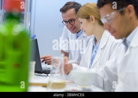 les scientifiques étaient assis en train de travailler sur un banc de laboratoire Banque D'Images