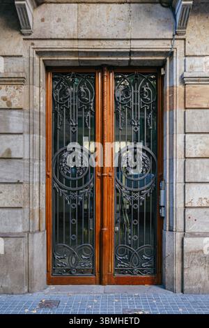 Fer forgé élaboré et porte d'entrée en bois d'Une résidence historique de Barcelone. Patrimoine architectural, métallurgie décorative, charme urbain, Traditio Banque D'Images