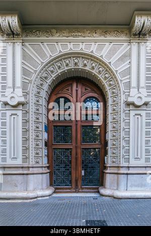 Magnifique entrée du bâtiment de Barcelone avec Archway en pierre complexe et porte en bois ornée. Architecture espagnole historique, chef-d'œuvre architectural, Banque D'Images