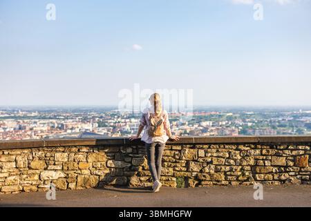 Femme voyageur solo debout aux murs vénitiens au-dessus de la ville basse Bergame, Italie et profitant de la vue panoramique de Citta Alta. Vacances en Europe Banque D'Images