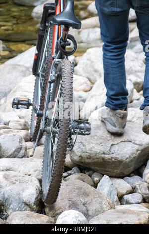 Le VTT navigue à pied dans un ruisseau rocheux Banque D'Images