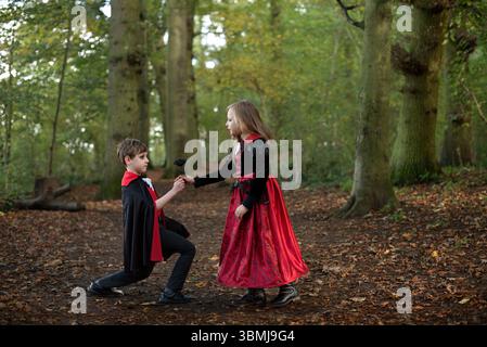 Deux enfants habillés pour halloween en costumes de vampire et de sorcière. Banque D'Images