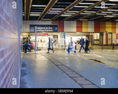Royaume-Uni, Londres, 30 juin 2025. Les gens marchant devant l'entrée du Barbican Centre sur un trottoir humide après les pluies dans la ville de Londres. Banque D'Images