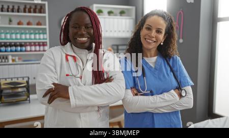 Deux médecins souriants se tiennent en toute confiance dans une chambre d'hôpital, mettant en valeur le travail d'équipe dans un environnement de soins de santé, avec des équipements médicaux en toile de fond. Banque D'Images