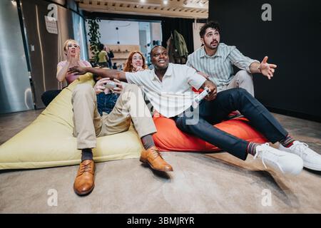 Groupe diversifié de collègues jouant avec enthousiasme à un jeu vidéo dans un salon confortable Banque D'Images