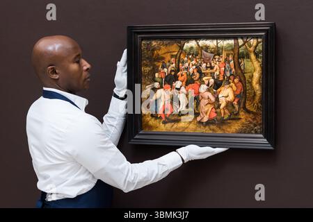 LONDRES, ROYAUME-UNI - 27 JUIN 2025 : un gestionnaire d'art tient une peinture intitulée 'The Outdoor Wedding Dance' de Pieter Brueghel le jeune, estimation : £800 000 - 1 200 000 lors d'un appel photo à la maison de vente aux enchères Sotheby's avant la vente des Old Masters à Londres, Royaume-Uni le 27 juin 2025. (Photo de Wiktor Szymanowicz/NurPhoto) Banque D'Images