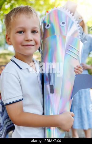 Smiling Boy tient Schultuete coloré en forme de requin rempli de cadeaux lors de son premier jour d'école en Allemagne. Cône brillant avec des ailerons et des yeux symbolise Banque D'Images