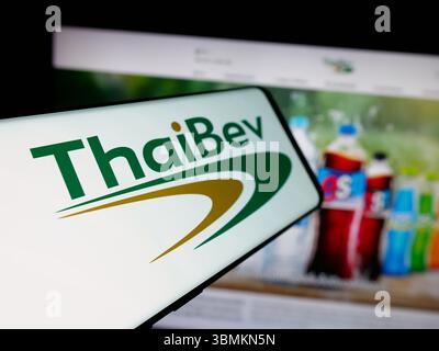 Stuttgart, Allemagne - 05-02-2025 : smartphone avec le logo de la société Thai Beverage plc (ThaiBev) sur l'écran en face du site. Banque D'Images