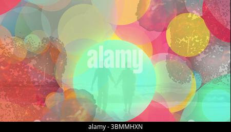 Couple senior marchant tenant les mains sur le rivage sablonneux peu profond, avec des cercles translucides au-dessus des vagues de la mer Banque D'Images