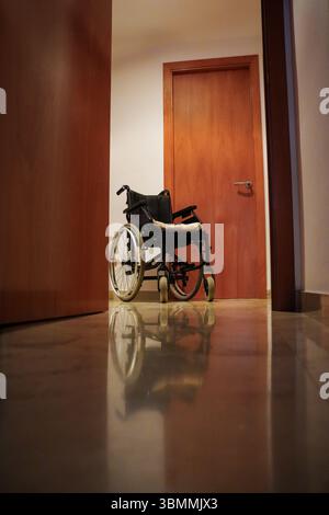 Fauteuil roulant dans le couloir d'une maison sans personnes. Banque D'Images
