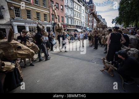 LONDRES, Royaume-Uni – 27 juin 2025 : les artistes manœuvrent des marionnettes animales en carton grandeur nature dans le West End dans le cadre des troupeaux, un publi de 20 000 kilomètres Banque D'Images