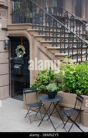 Une charmante terrasse avec des sièges élégants, des plantes décoratives et un bel escalier en fer souligne la beauté urbaine. Banque D'Images