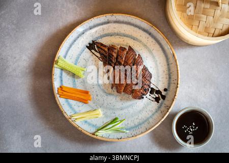 Canard laqué avec des lanières de légumes Banque D'Images