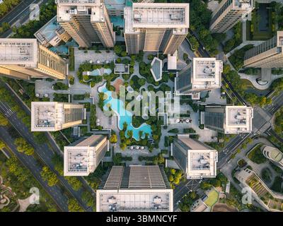 Vue aérienne de haut en bas du quartier résidentiel moderne avec verdure, éléments aquatiques et espaces de loisirs en milieu urbain. Banque D'Images
