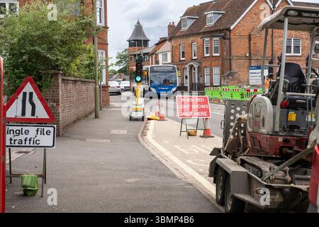 Lorsque le feu rouge s'allume, attendez ici le panneau d'instructions pour la circulation sur Winchester Road en raison de travaux routiers avec feux de circulation temporaires et cônes. Basingstoke, Royaume-Uni Banque D'Images