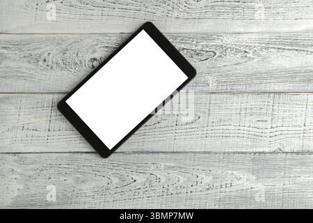 Tablette électronique noire sur fond en bois blanc shabby vintage. la vue depuis le haut. pose à plat Banque D'Images