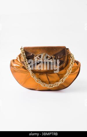 Sac à main orange fait à la main sur un fond blanc, sac à main en cuir orange fait à la main, sac à main artisanal en or orange avec une poignée courte en chaîne Banque D'Images