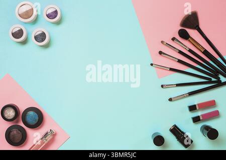 Articles de maquillage essentiels. Ensemble de pinceaux de maquillage professionnels, crèmes et ombres en pots sur fond bleu. Place pour votre texte ou logo. Idéal pour la beauté Banque D'Images