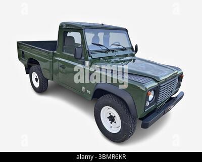 Camionnette verte classique Land Rover Defender garée sur un fond blanc, incarnant l'aventure et l'utilité Banque D'Images