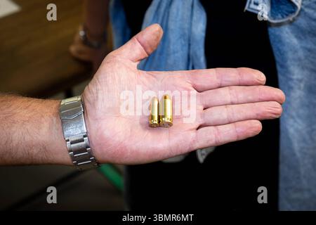 Landkreis Osnabrück, Deutschland 25. Juni 2025 : Im Bild : eine offene Handfläche hält zwei unterschiedliche Patronen für Handfeuerwaffen, um deren Größenunterschied zu demonstrieren. Die Patronen sind aus glänzendem Messing gefertigt und bestehen aus Hülse, Geschoss und Zündhütchen. DAS Bild betont die physischen Eigenschaften von scharfer munition und ihre Rolle im Sportschießen oder BEI der Jagd. Die Details der hand und der Armbanduhr lenken den Blick auf die Präsentation der munition. Landkreis Osnabrück Niedersachsen *** District de Osnabrück, Allemagne 25 juin 2025 dans la photo an open PA Banque D'Images
