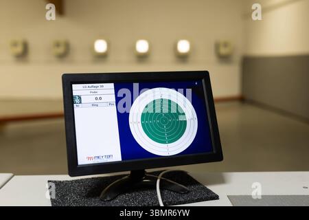 Landkreis Osnabrück, Deutschland 25. Juni 2025 : Im Bild : Ein LCD-Monitor mit der Aufschrift MEYTON zeigt eine digitale Darstellung einer Zielscheibe, die für das Luftgewehr LG Auflage 30 Schießen verwendet wird. Der Bildschirm ist Teil eines modernen elektronischen Zielerfassungssystems auf einem Schießstand. Er zeigt präzise die Trefferlage und die erzielten Ringe an, was eine sofortige Rückmeldung für den Sportschützen ermöglicht. IM Hintergrund sind weitere beleuchtete Zielscheibenbereiche oder Lichterreihen erkennbar, die auf die Infrastruktur eines professionellen oder modernen Schießstan Banque D'Images