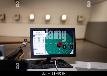 Landkreis Osnabrück, Deutschland 25. Juni 2025 : Im Bild : Ein LCD-Monitor auf einem Schießstand zeigt die Ergebnisse des Luftgewehr LG Auflage 30 Schießens, mit einem deutlichen Treffer im Zentrum der digitalen Zielscheibe. Die Anzeige 65,0 signalisiert eine beeindruckende Gesamtpunktzahl, während die Tabelle links detaillierte Informationen zu den einzelnen Schüssen liefert, darunter eine 10,9 für Schuss Nummer 10 der höchstmögliche Wert im Präzisionsschießen. IM Vordergrund ist unscharf der Lauf eines Luftgewehrs mit Holzschaft zu sehen, was die Perspektive des Schützen widerspiegelt. Der Hin Banque D'Images