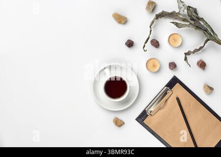 Journal ouvert avec un crayon sur la table près de tasse de thé noir. Haut de la vue, télévision lay. Copier l'espace. Still Life Banque D'Images