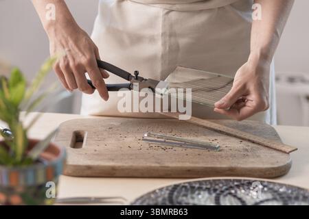 Feuilles à découper l'artiste du vitrail en petits carrés de mosaïque. Close-up. Atelier. Lieu de travail Banque D'Images