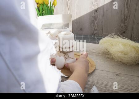 Femme méconnaissable créant une décoration de vacances de Pâques à partir de coquille d'œuf de matériaux durables. DIY faites-le vous-même étape par étape instruction. Presen cadeau Banque D'Images