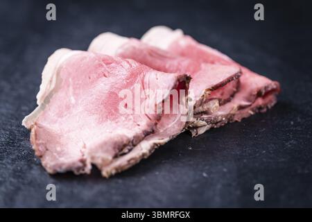 Partie de tranches de Roastbeef grillé moyen sur une dalle d'ardoise (selective focus) Banque D'Images