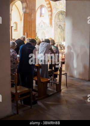 Alseno, Italie 22 juin 2025 les touristes et les dévots assistent à la messe et prient pendant les célébrations du Corpus Christi dans l'abbaye cistercienne de Banque D'Images
