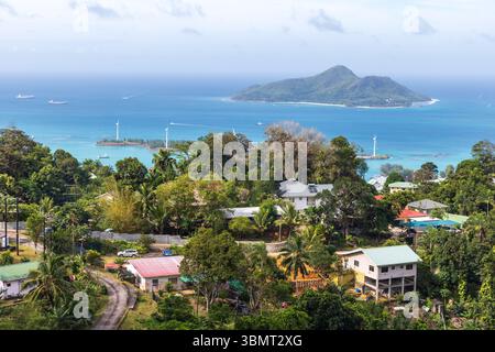 Île de Mahé, Seychelles. Un cadre tropical insulaire avec un littoral animé, des maisons nichées au milieu de la verdure et un océan tranquille Banque D'Images