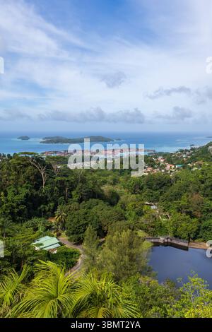 Île de Mahé, Seychelles. Une vue vibrante sur une île tropicale avec une ville côtière, une végétation luxuriante et un océan bleu. Le paysage met en valeur le harmon Banque D'Images