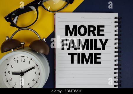 Plus de texte de temps de famille écrit sur le bloc-notes avec réveil sur fond bleu Banque D'Images