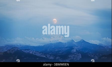 Gros plan d'une belle lune montrant au-dessus des Alpes françaises et suisses Banque D'Images
