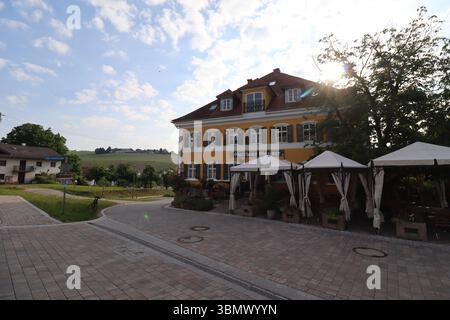 KIRCHDORF, ALLEMAGNE - 19 JUIN 2025 : vue extérieure de Gasthaus Grainer à Kirchdorf avec lumière du soleil le matin et sièges extérieurs sous des parasols blancs Banque D'Images