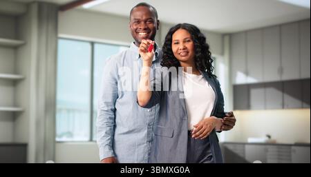 Heureux couple tenant des clés montrant la nouvelle maison à Portrait de famille Banque D'Images