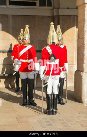 Cérémonie de relève de la garde avec les gardes du Roi et de la Reine en uniformes traditionnels, Londres, baignée de soleil. Banque D'Images