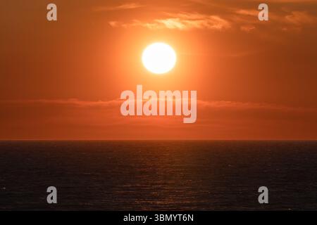Beau coucher de soleil orange sur les eaux calmes de la mer Baltique. Paysage marin pittoresque, un fond idéal pour les voyages et la détente. Banque D'Images