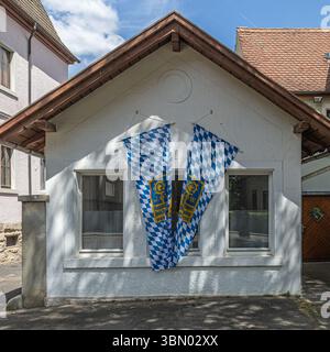 Rothenburg ob der Tauber, Bavière, Allemagne - 24 mai 2025 : façade de maison avec drapeaux bavarois suspendus. Banque D'Images