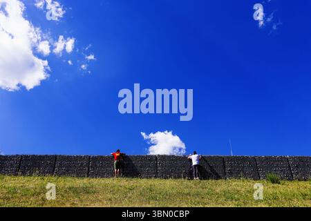 Spielberg, Autriche. 29 juin 2025. Sport automobile : Championnat du monde de formule 1, Grand Prix d'Autriche, course : deux spectateurs regardent la course au-dessus d'un mur. Crédit : Philipp von Ditfurth/dpa/Alamy Live News Banque D'Images