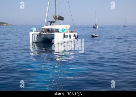 Catamaran ancré dans la mer bleue calme Banque D'Images
