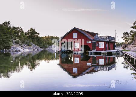 Chalets rouges sur l'île Harstena en Suède, principalement connus pour la chasse au phoque qui y était autrefois pratiquée. C'est maintenant une attraction touristique Banque D'Images
