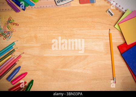 Crayon jaune aiguisé est assis sur le bureau de design plat encadré par la papeterie colorée, espace de copie Banque D'Images