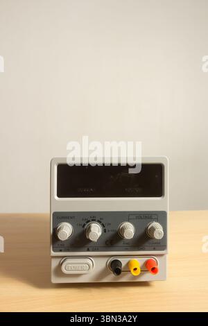 bloc d'alimentation c.c. numérique isolé verticalement sur un espace de copie de fond blanc Banque D'Images