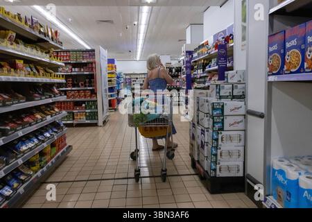 Les acheteurs de nourriture recherchent le long d'une allée dans un supermarché de Sainsbury, Angleterre, Royaume-Uni Banque D'Images
