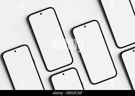 Cinq smartphones avec écran blanc vierge sont couchés sur une table blanche, utile pour présenter des applications ou la conception Web. Rendu 3D. Banque D'Images