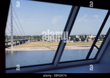 Duesseldorf, Allemagne. 30 juin 2025. Vue depuis la fenêtre de la Chancellerie d'État sur les rives sèches du Rhin, où est installé le salon funiculaire du Rhin. Dans les prochains jours, il fera très chaud en Allemagne avec des températures de plus de 30 degrés. Crédit : Rolf Vennenbernd/dpa/Alamy Live News Banque D'Images
