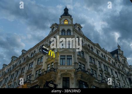 VIENNE, AUTRICHE - 11 AOÛT 2024 - Un bâtiment classique de Vienne arborant des logos de multinationales, symbole de la culture de consommation moderne. Banque D'Images
